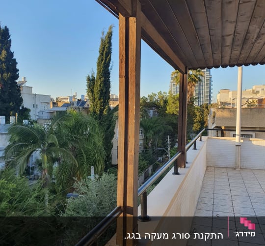מעקה מתכת על מרפסת עם עמודי עץ